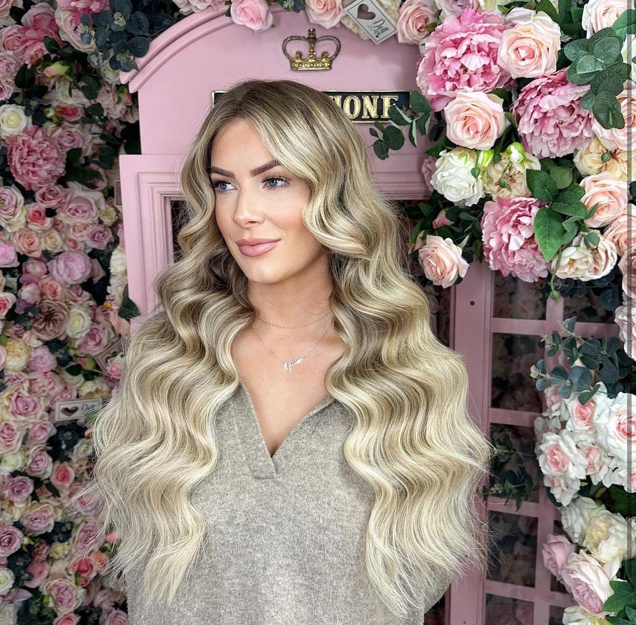 A WOMAN WEARING TAPE IN HAIR EXTENSIONS